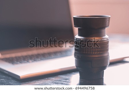Table with photo equipment, computer and Lens.