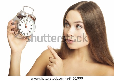 Portrait of the girl showing a finger on an alarm clock, isolated on white background.