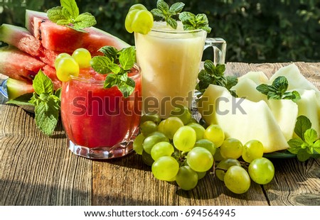Watermelon and melon smoothies. On a blurred green background. close-up