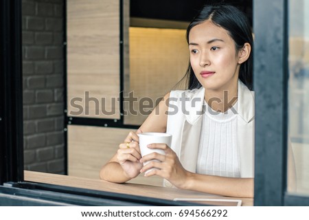 Young woman drinking relaxing coffee in coffee shop