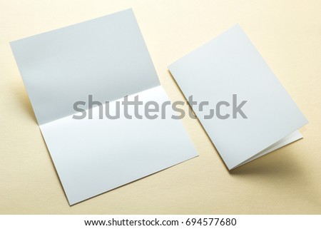 Empty paper flyers, business cards, brochures on a yellow background, layout. Space for text.