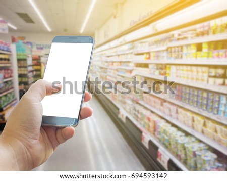 Close up of hands holding cell telephone blank copy space screen. smart phone with technology concept. Abstract blur supermarket and retail store in shopping mall interior for background