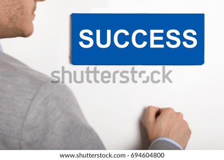 Close-up Of A Young Businessman Knocking White Door With Success Text