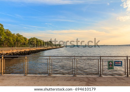 BROOKLYN, NY (August 10, 2017) - Midday at Pier 69 in Bay Ridge with the view of the Belt Parkway and the Verrazano Bridge in the background under a blue, orange sky. 
