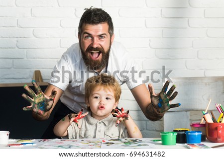 Joy family art, happy father and son show hands in bright colors, paint together picture, art for whole family, cheerful drawing teacher. Home education with parents. Happy childhood. Hands in paint