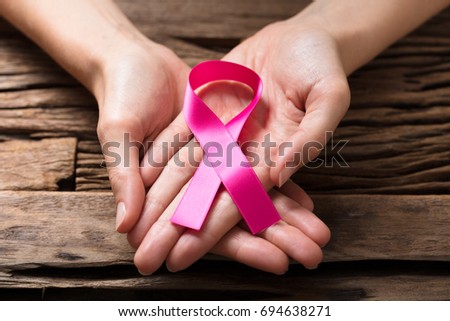 Close-up Of A Human Hand Showing Pink Ribbon To Support Breast Cancer Cause