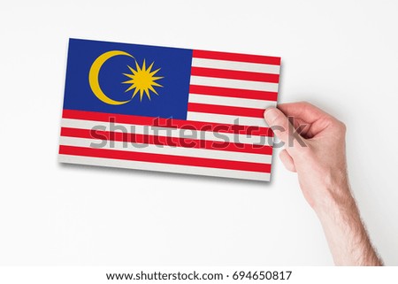 Male hand holding malaysia flag