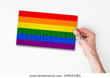 Male hand holding gay pride flag