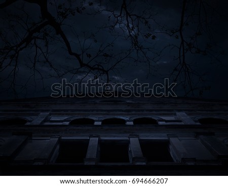 Horror scene of old grunge castle over dead tree, moon and cloudy sky, Spooky background, Halloween concept