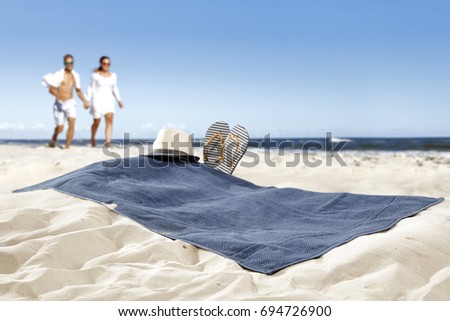 towel on beach of free space for your decoration and two lovers on sand 