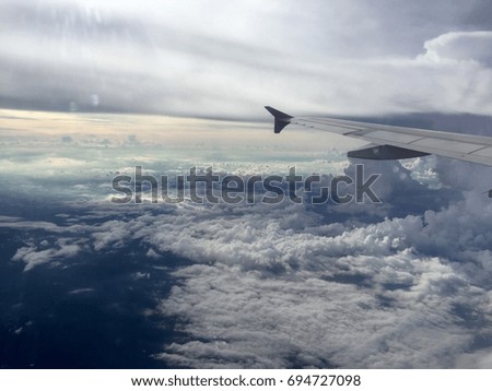 An aerial silhouette picture of white carpet of fluffy clouds, taken from an airplane