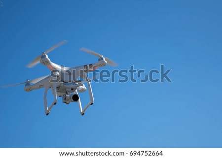 Professional quadcopter drone flying in blue sky