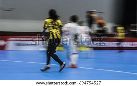 Motion Blur. Panning. Picture with camera made motion blur effect of a futsal match at indoor court.