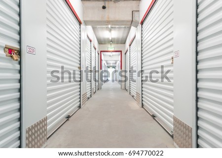 Hallway with white storage units. Concrete floor Royalty-Free Stock Photo #694770022