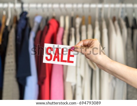 Clothes hanging in hanger in a rack and wardrobe in a fashion store with discount and bargain prices. 