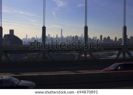 This is a picture of the sunset over midtown taken from the Triboro Bridge. You can see cars going by the foreground and the city in the background