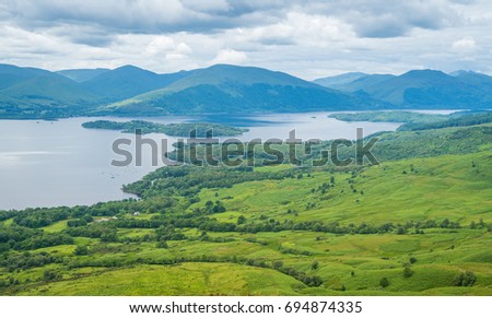 Panoramic sight from Conic Hill, Balmaha, village on the eastern shore of Loch Lomond in the council area of Stirling, Scotland. Royalty-Free Stock Photo #694874335