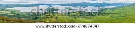 Panoramic sight from Conic Hill, Balmaha, village on the eastern shore of Loch Lomond in the council area of Stirling, Scotland. Royalty-Free Stock Photo #694874347