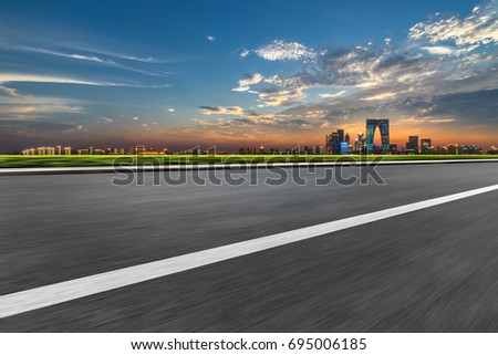 clean asphalt road with city skyline background, china.
