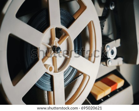 film projector on a black background with dramatic lighting and selective focus. Reel with film.
