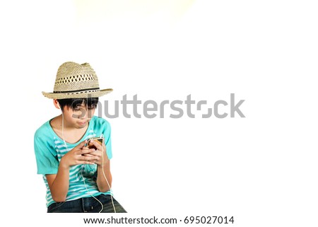 cute boy play mobile phone and listen to music on isolate on white.Asia handsome boy.smart kid look at mobile phone. 