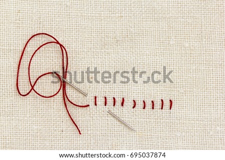 Stitches and needle - proverb: One stitch in time saves nine. Royalty-Free Stock Photo #695037874