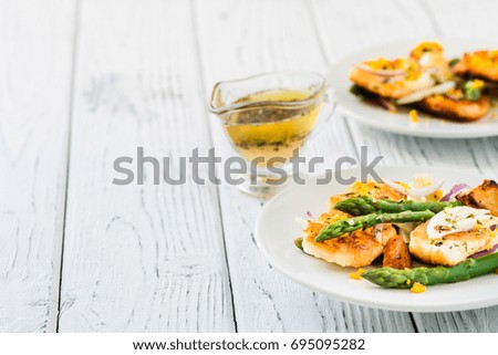 Salad with fried halloumi, asparagus and orange zest. Copy space. White wooden background