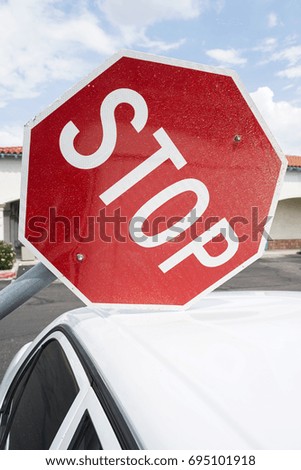 road sign STOP on roof of a white car