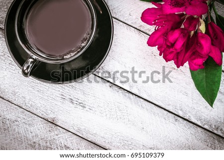 book, cup of coffee and Rhododendron flowers on wooden background. cover, card. copy space.