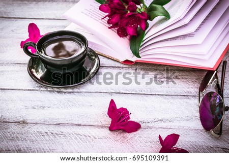 book, cup of coffee, sunglasses and Rhododendron flowers on wooden background. cover, card. copy space.