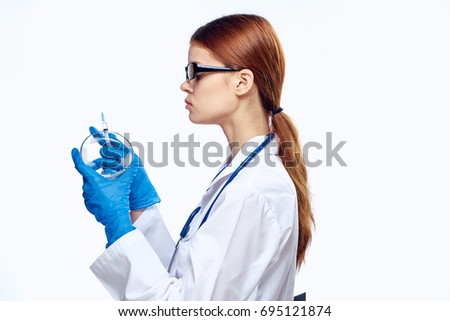 Woman doctor with glasses with a cup of petrie on a light background                               