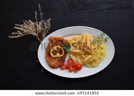 fried cheese with potato and fresh vegetables on wood table