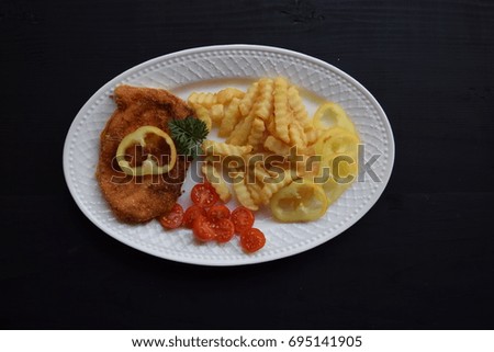 fried cheese with potato and fresh vegetables on wood table