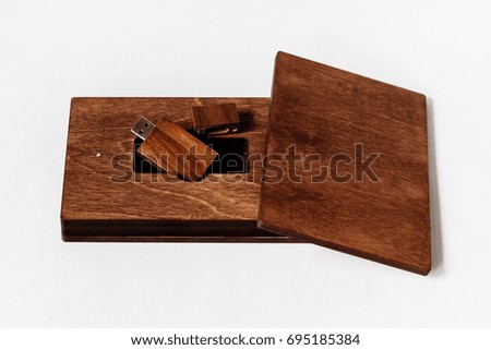 Packaging for USB drive. Dark Wooden box with USB-storage for a photographer, on a white isolated background. Copy space