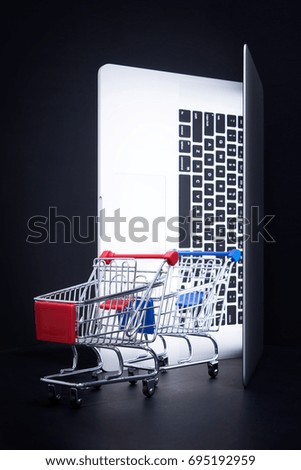 Laptop open like door with a empty shopping cart , online marketing and business trading concept.