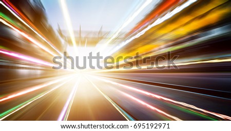 Foward motion speed lens blur racing circuit background with seated stand and light trail effect .