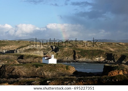 Church in the coast, Hermitage of the Virgin of the port in Meirás, Galicia, Spain, with rainbow, landscape of the sea, design for advertising, space for promotional text,