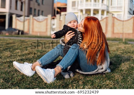 Mother and son on vacation on green grass sunny summer day. Family spending time together