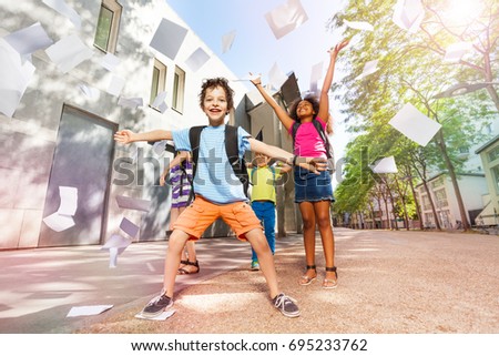 Happy boy throws papers in the air very excited Royalty-Free Stock Photo #695233762