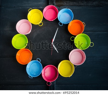 Creative colorful pot clock design with  black wood background.