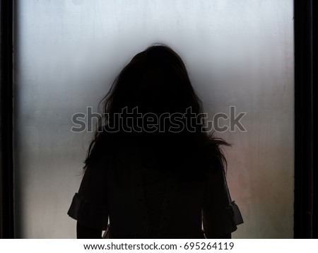 Ghost girl silhouette standing in front of window