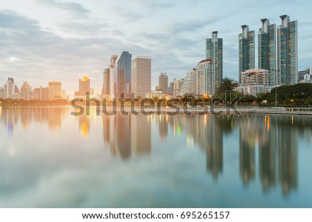 Reflection city office building at blue twilight night view, cityscape background