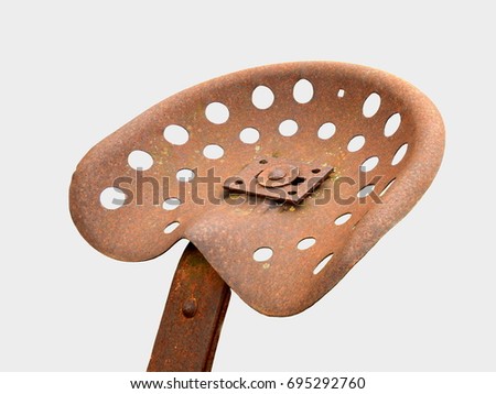 Close up of a rusty metal tractor seat isolated on a white background