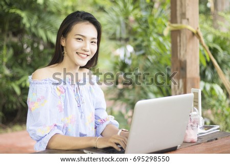 Smiling asian business women working with laptop in garden