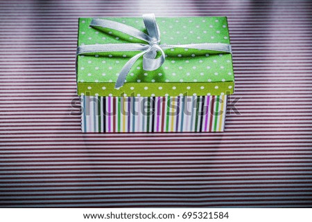 Gift box on red striped fabric top view celebrations concept