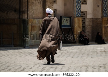 Mullah walking in Isfahan Royalty-Free Stock Photo #695332120