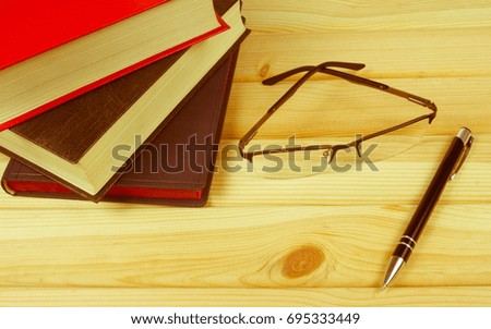Book with glasses on the wooden background. Education concept.