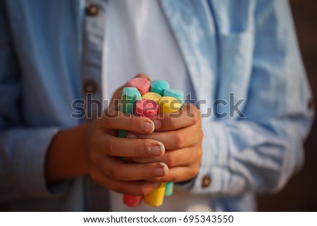 Closeup childs hands holding colored chalks for drawing