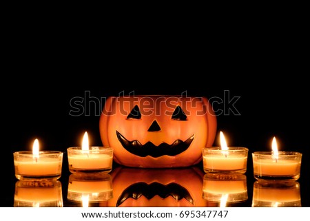 Halloween pumpkin scary face with candle on black background