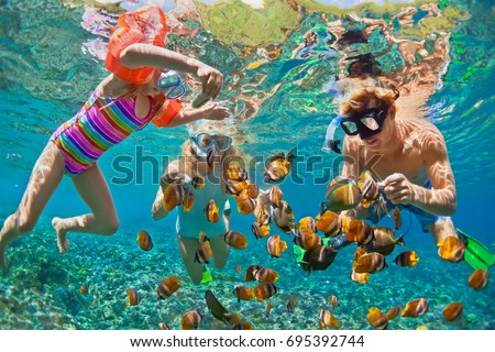 Happy family - father, mother, child in snorkeling mask dive underwater with tropical fishes in coral reef sea pool. Travel lifestyle, water sport adventure, swimming on summer beach holiday with kids Royalty-Free Stock Photo #695392744
